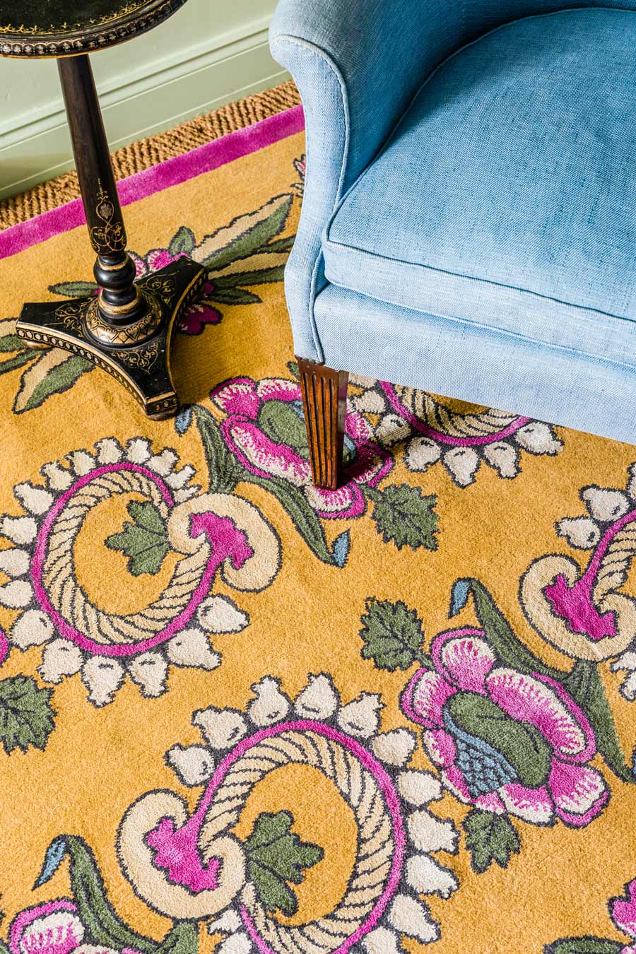 close up of kandilli rug by anna spiro in abstract floral pattern mustard background and pink border