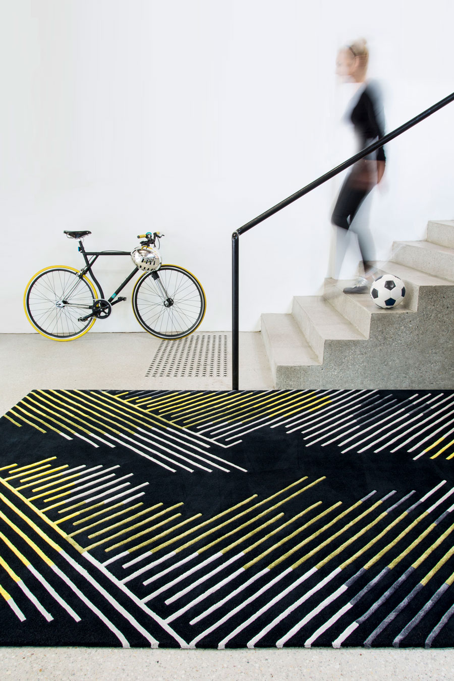 location shot of minotu rug by bleux in multi linear pattern black background