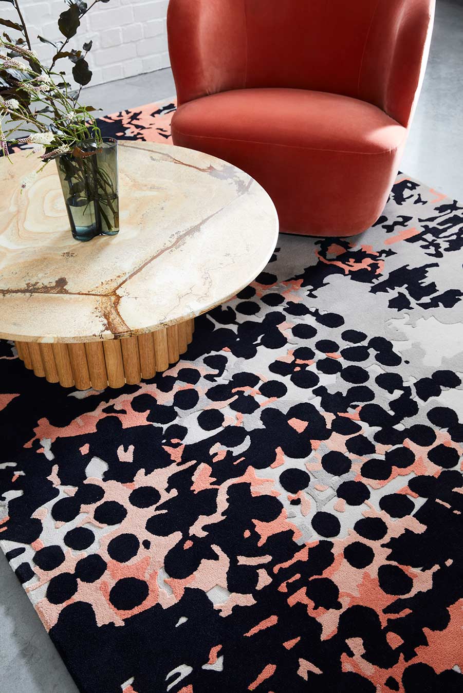 Living room view of modern, spotted Franco rug in Light grey, charcoal, pink and red.