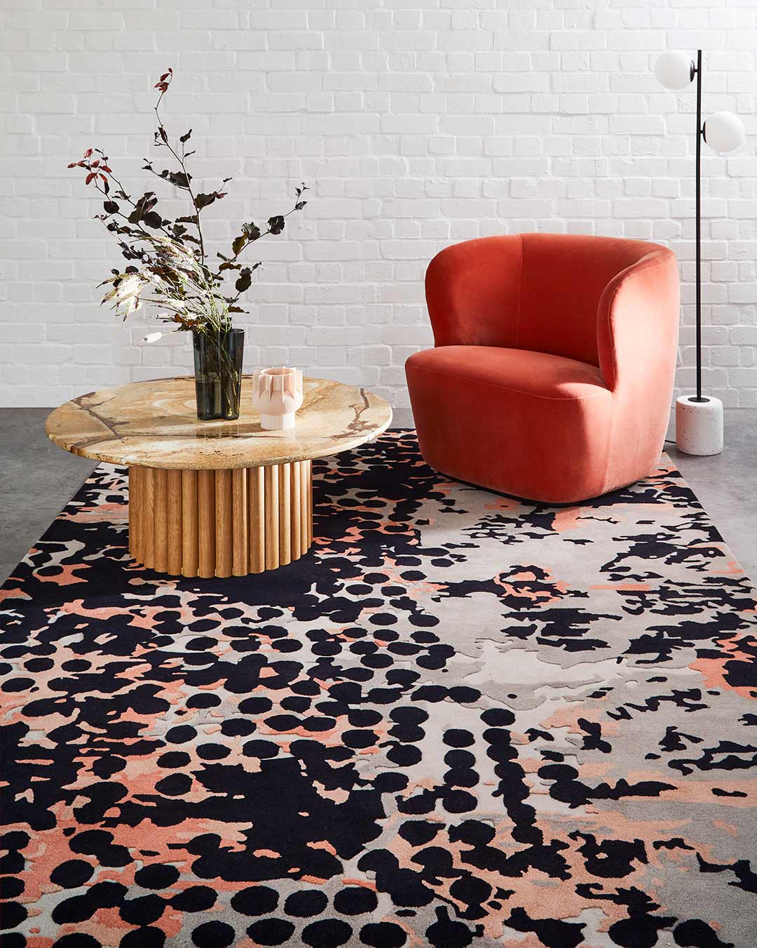 Living room view of modern, spotted Franco rug in Light grey, charcoal, pink and red.